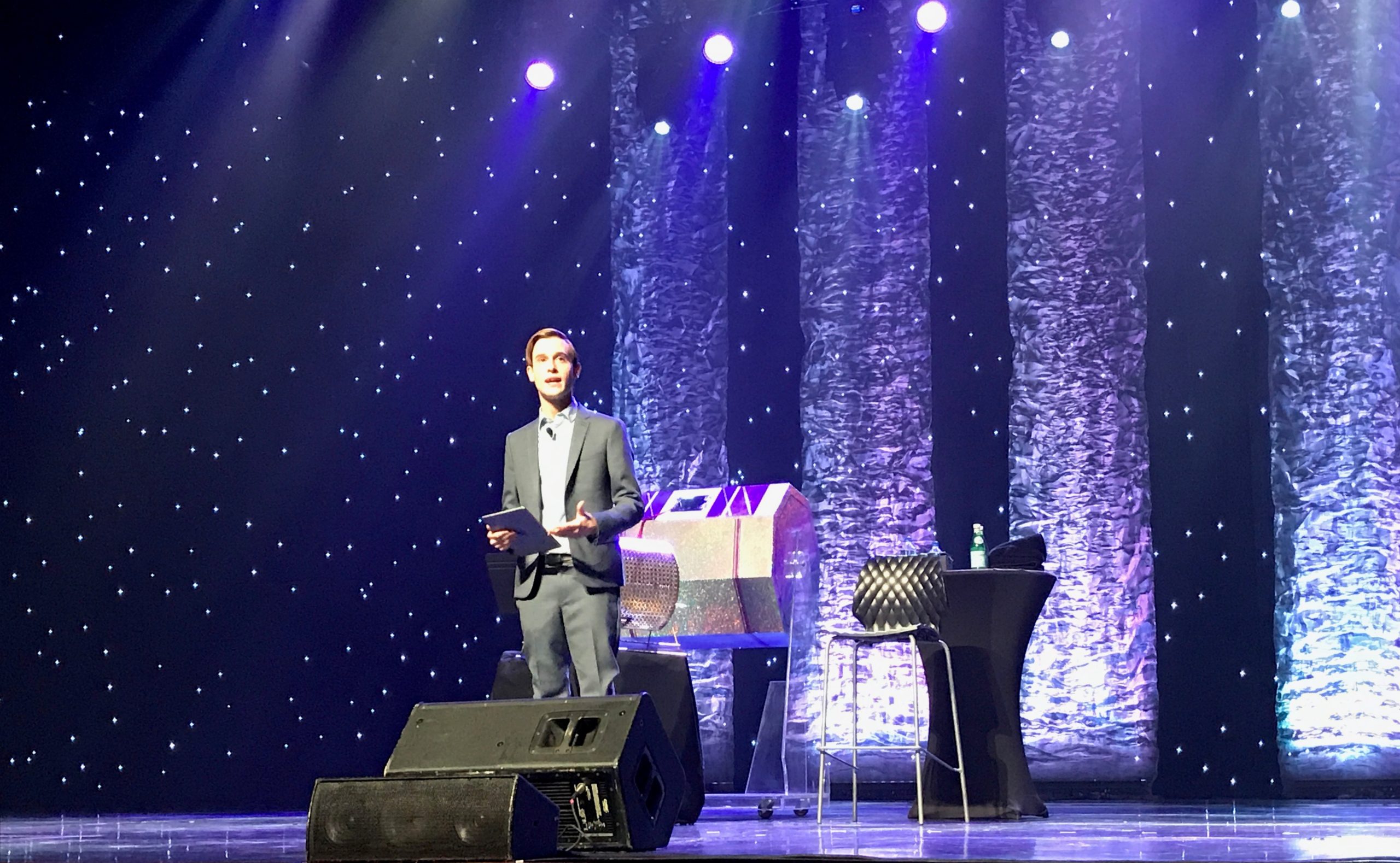 Tyler Henry performing under purple light on stage.